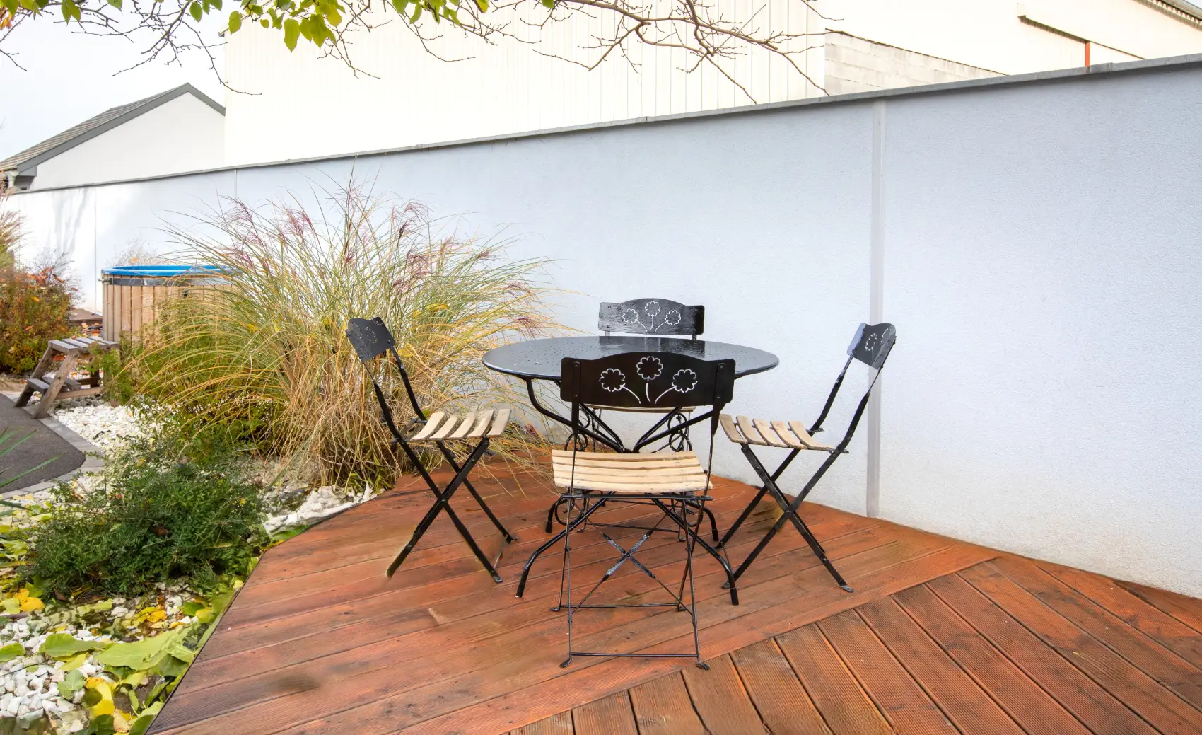 Terrasse privée du gîte Porte D avec table en bois et chaises extérieures, attenante au coin détente.